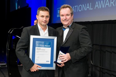 Mike Neale receives his award from Harcourts International managing director Mike Green.